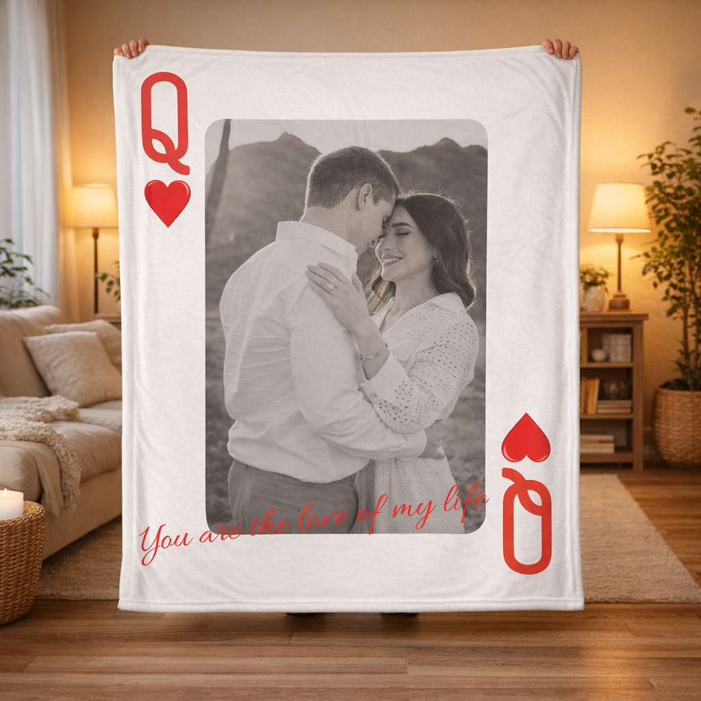 Blanket with a printed design of a couple and card symbols, held in a living room.