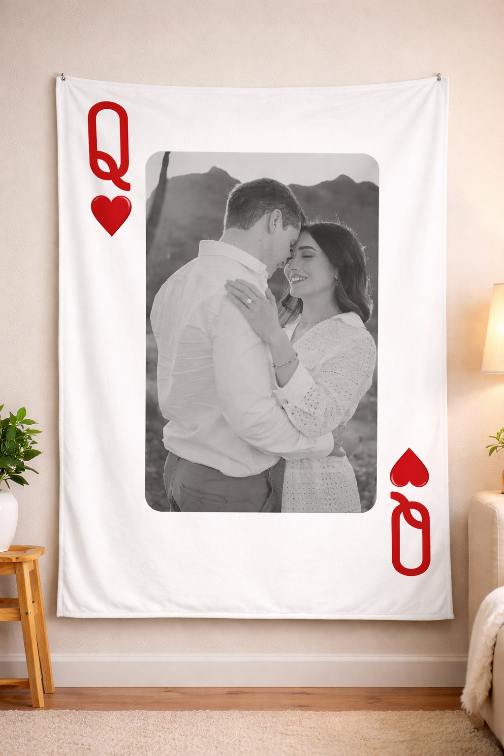 Tapestry with a Queen of Hearts design and a couple embracing, hanging on a wall.